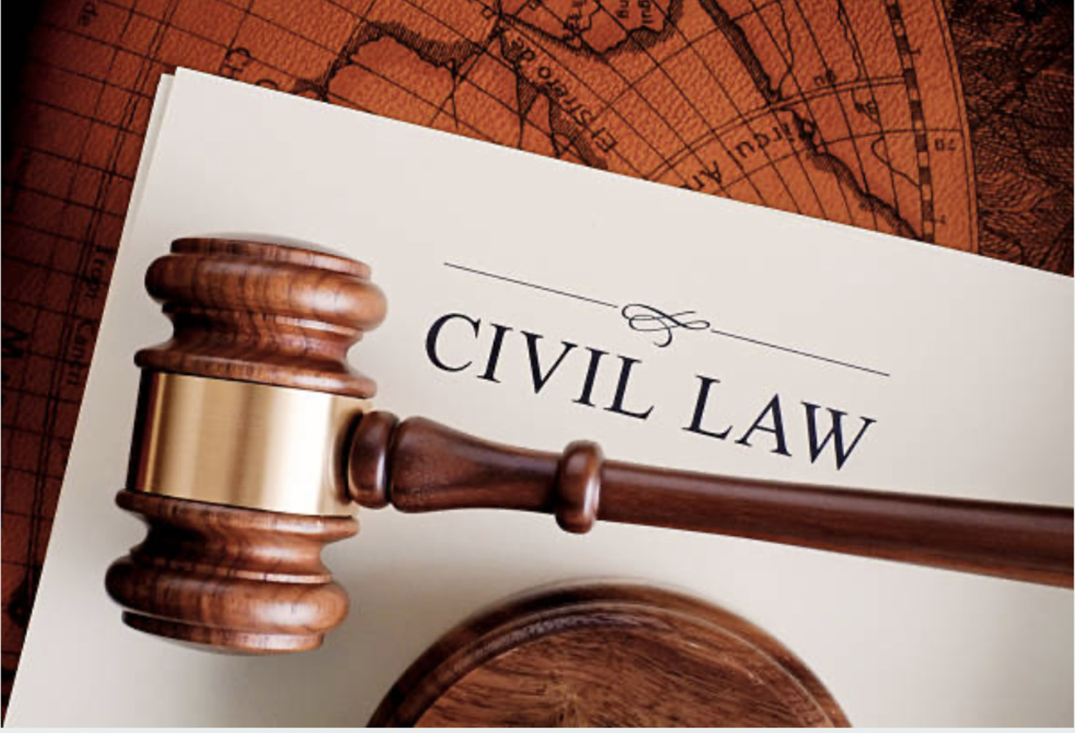 A wooden gavel rests on a document labeled "Civil Law," placed on a desk with a partially visible world map.